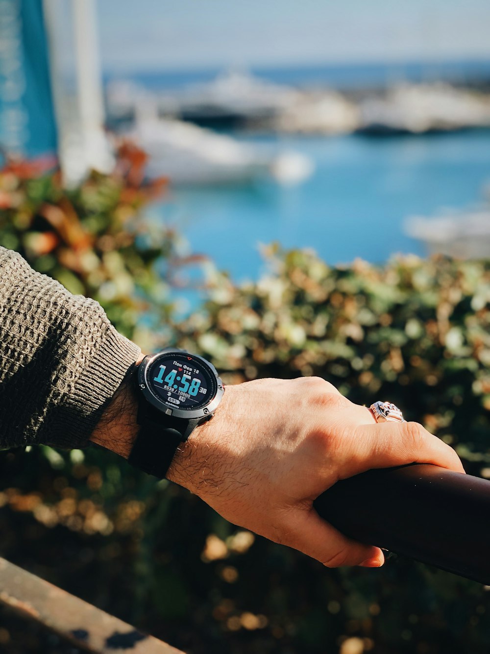 person wearing digital watch holding onto rail