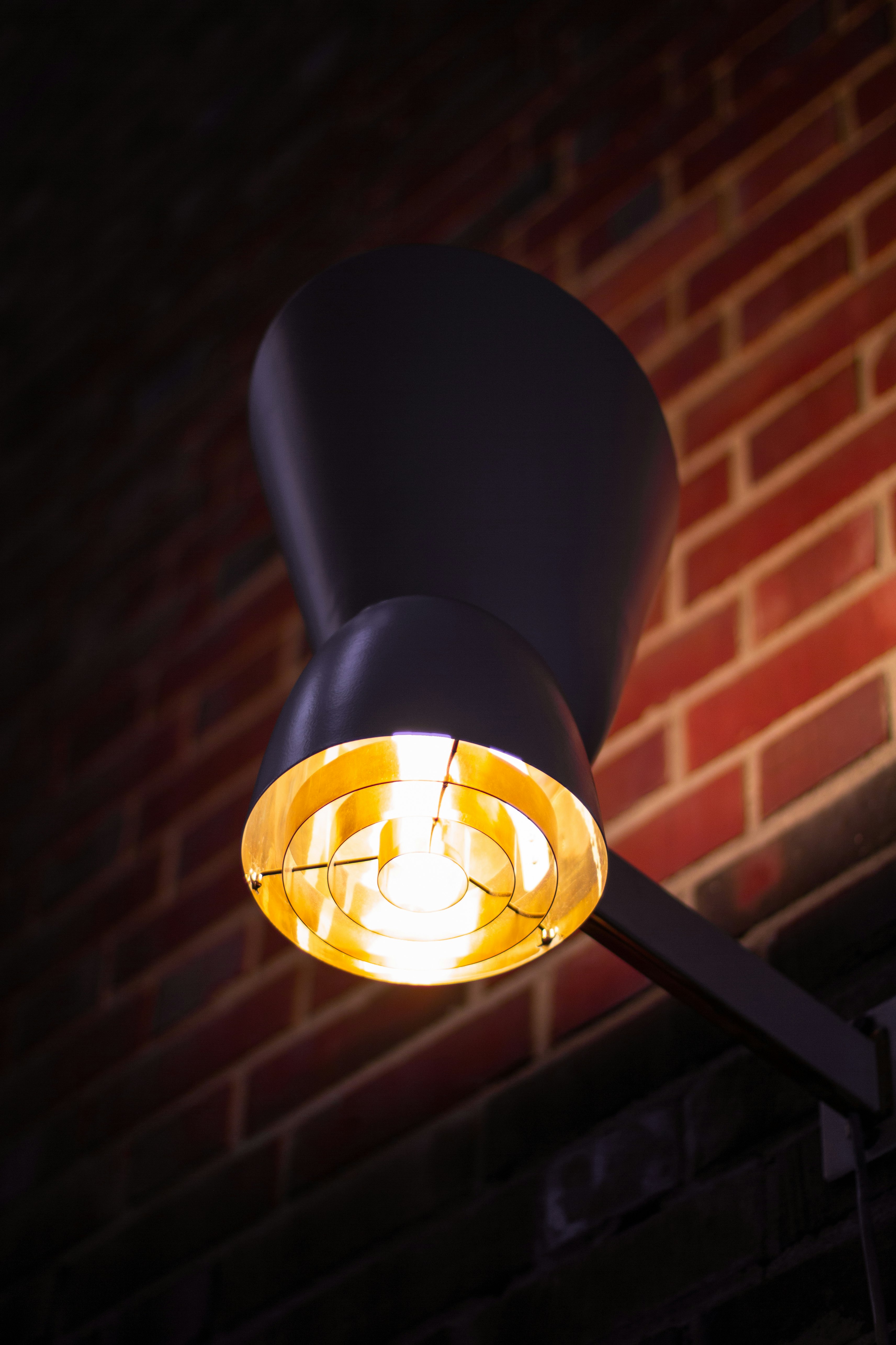 selective focus photography of turned-on black sconce lamp