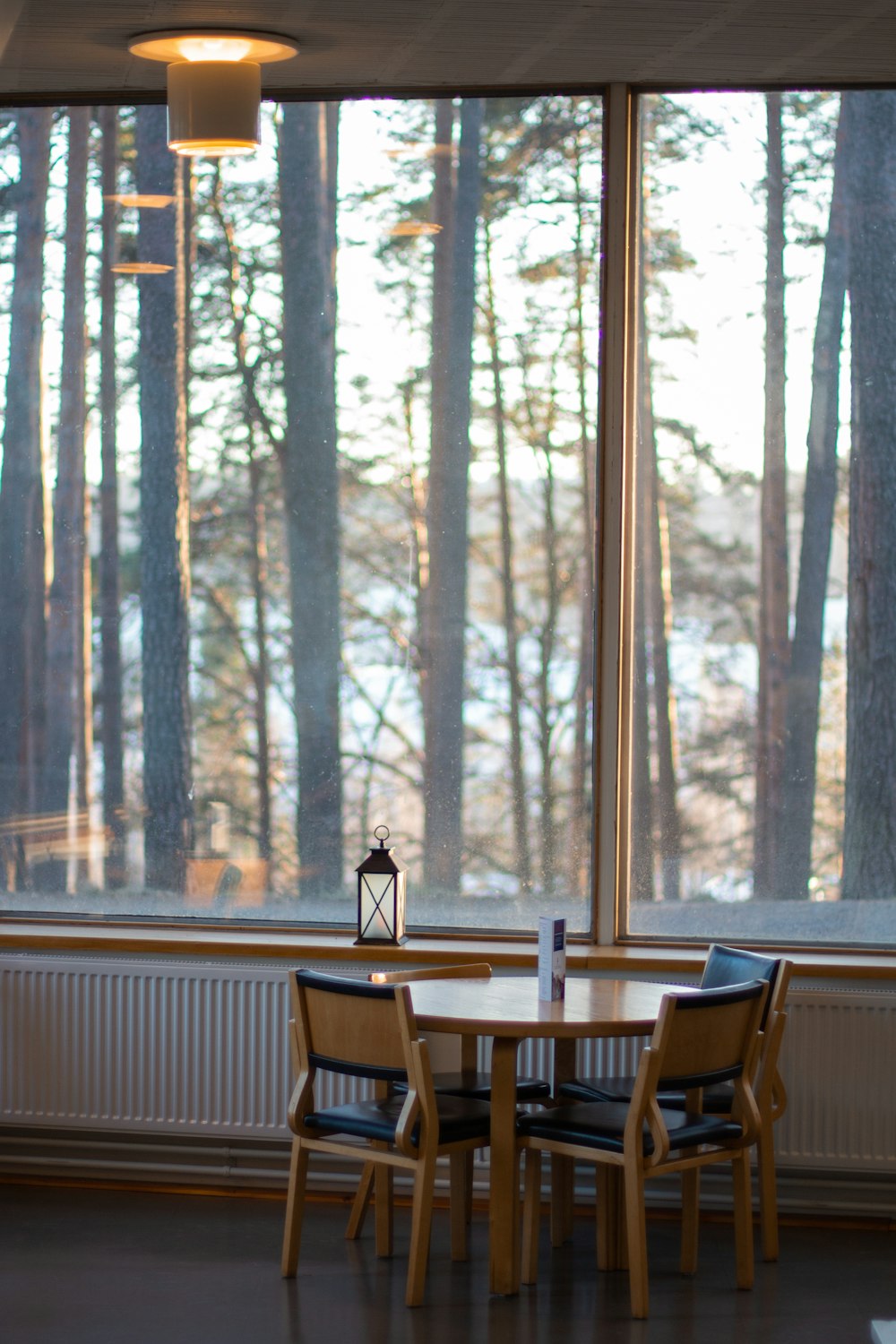 tavolo di legno marrone vuoto accanto alle sedie accanto al muro