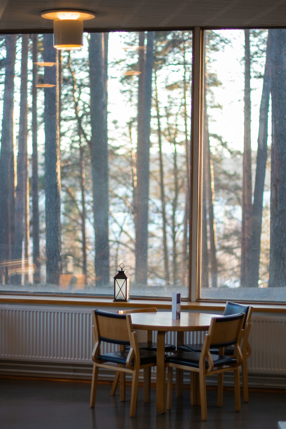 empty brown wooden table beside chairs beside wall