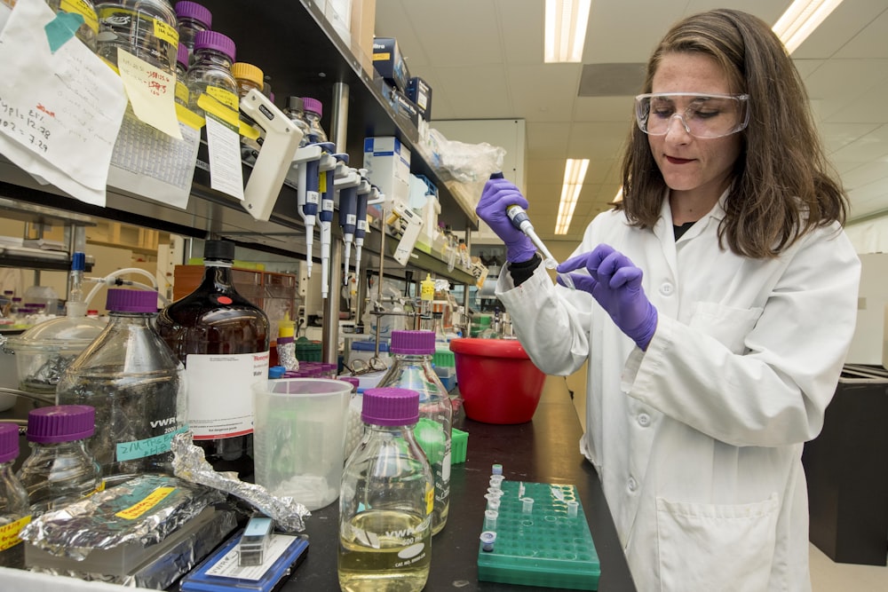 woman wearing lab coat and purple gloves