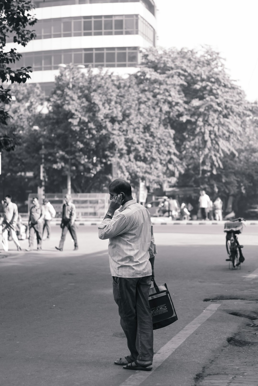 grayscale photography of standing person beside road during daytime