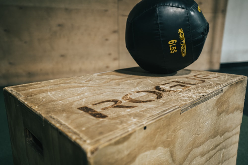 bola de cuero negro sobre mesa de madera marrón