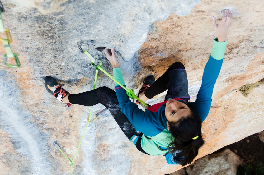 woman climbing rock formation