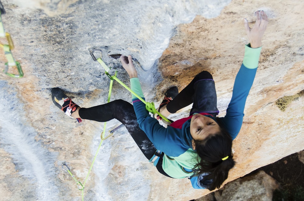 woman climbing rock formation