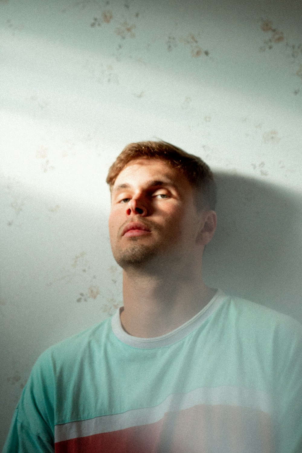 man leaning on white painted wall