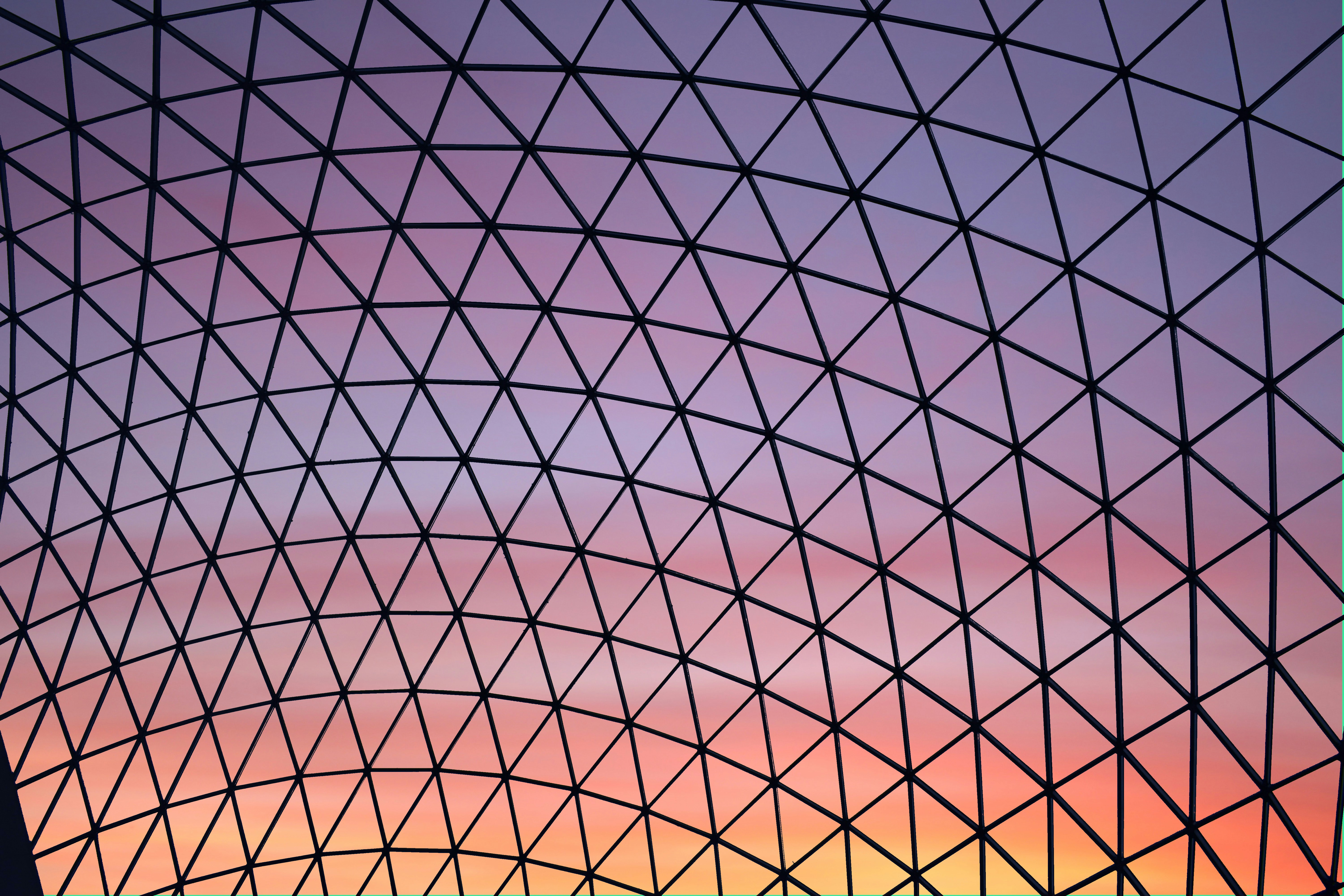 fotografía de ángulo bajo del techo del edificio de cúpula de vidrio transparente durante la hora dorada