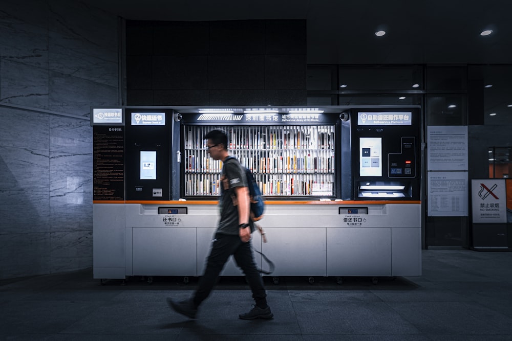 time-lapse photography of man passing by a storefront