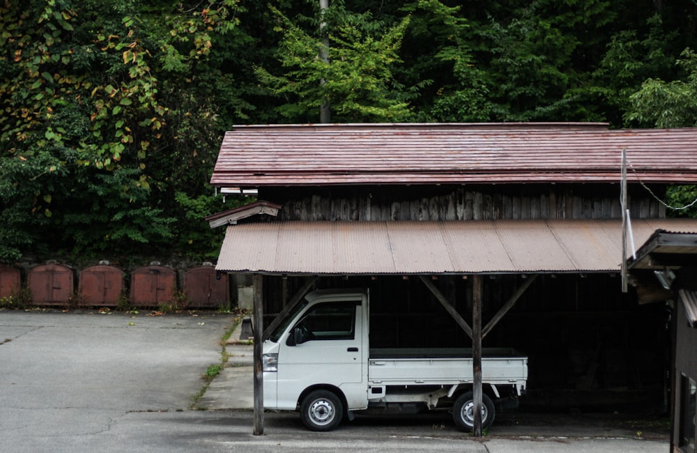 white drop-side pickup on a garage