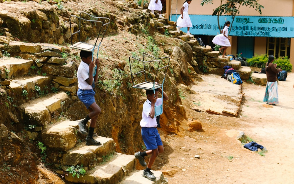 two boys carrying blue chairs