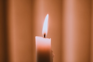 A close-up of a flickering candle flame casting soft shadows in a serene setting.