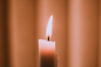 An elegant candle glowing softly in a serene setting, evoking a sense of calm.