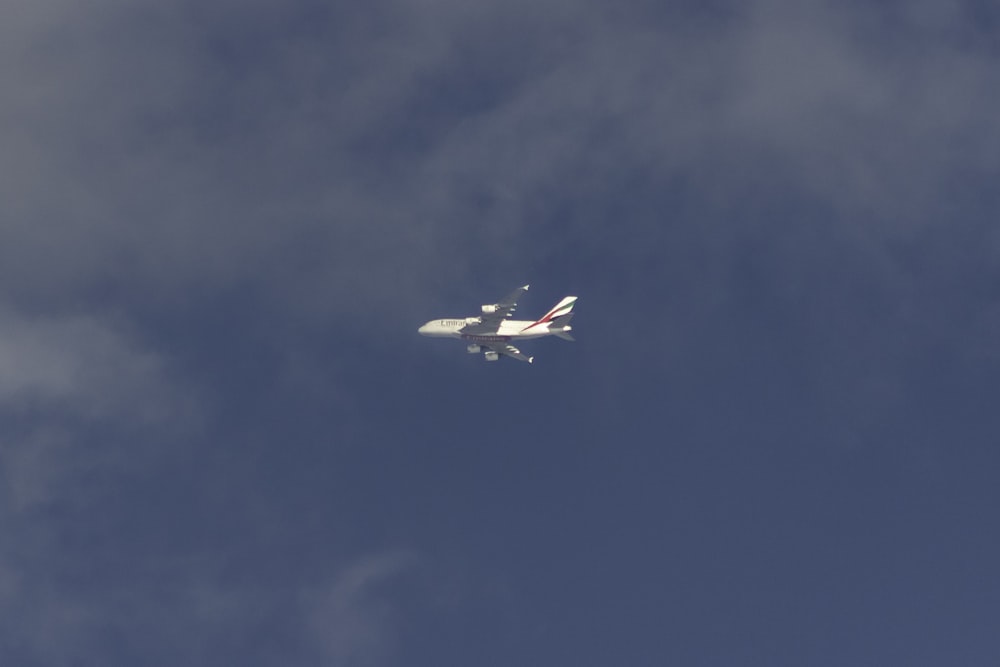 white airliner flying on sky