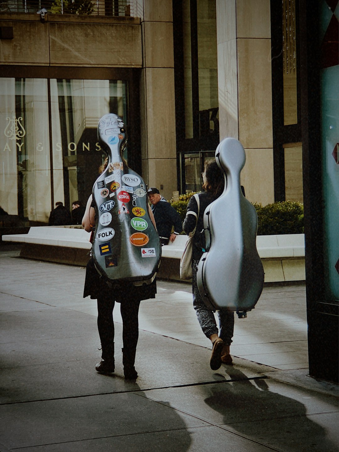 two men carrying guitar cases