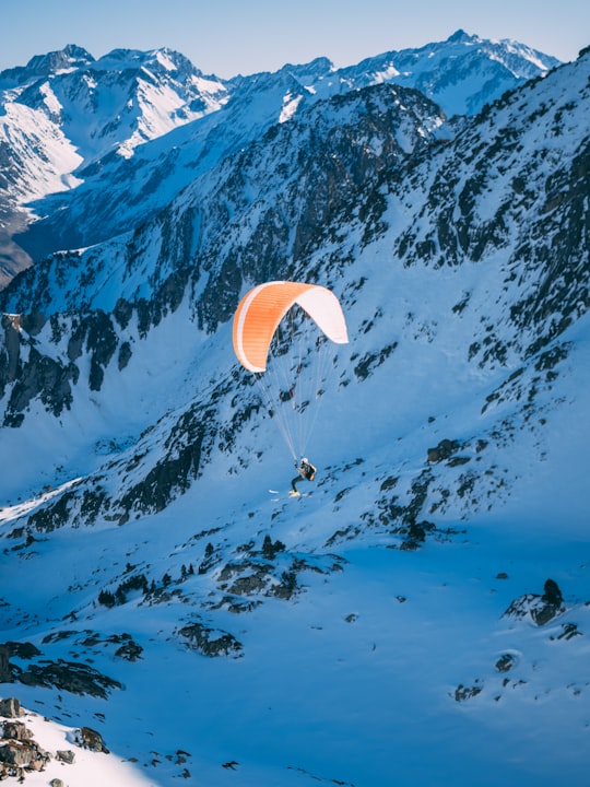 person riding parachute above glacier mountains and snowfield in Luz-Saint-Sauveur France