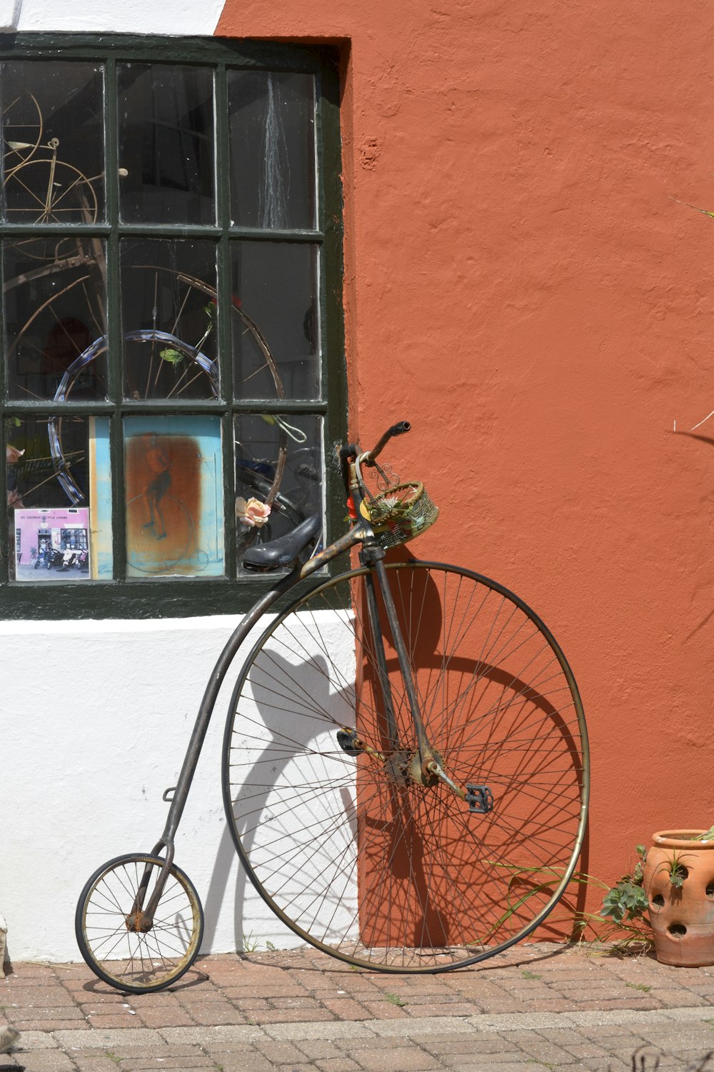 black Penny Farthing bike leaning on wall