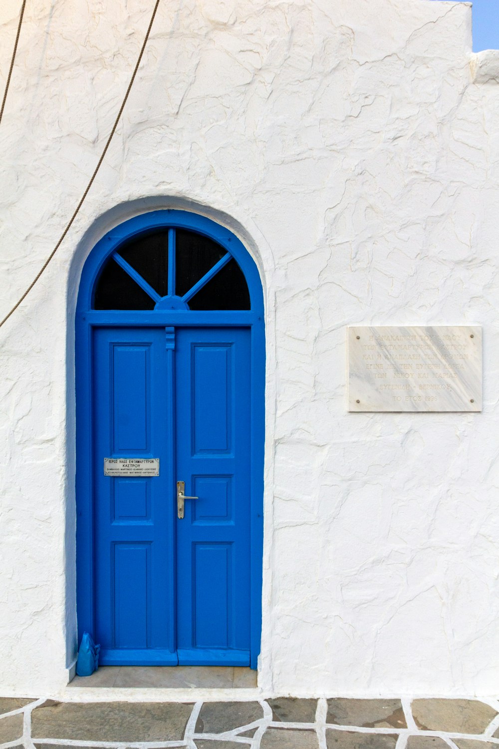 Minimalistische Fotografie einer blauen Tür in einem weißen Gebäude