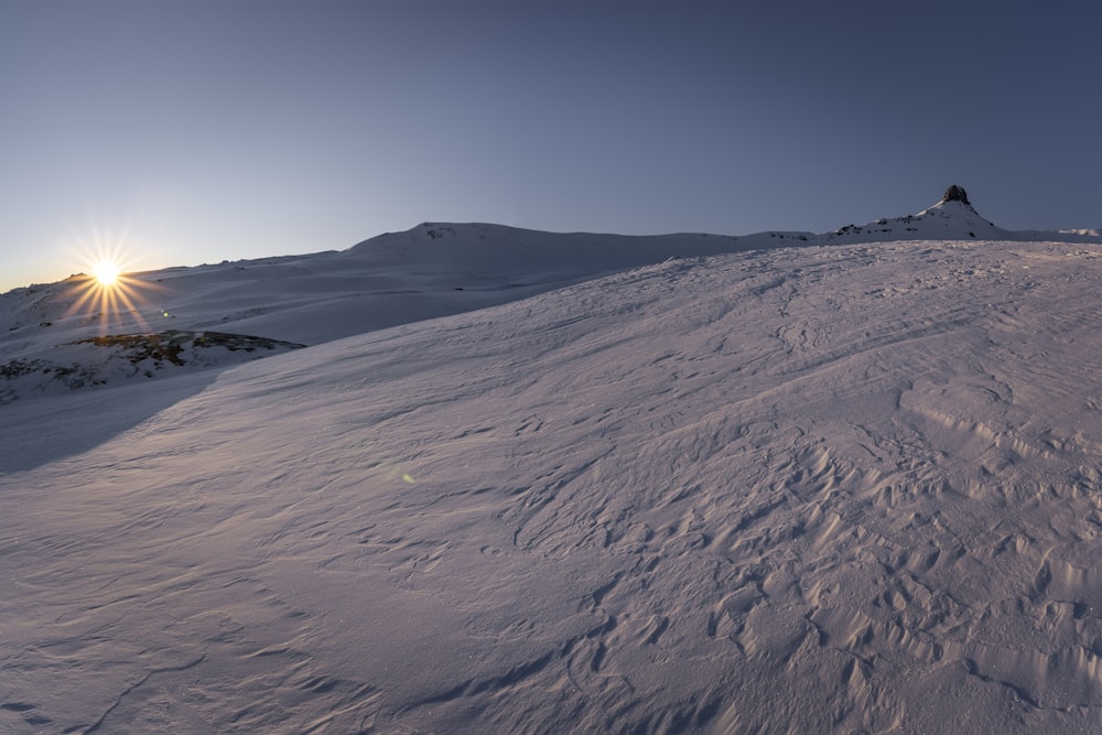 Fotografía de paisaje de campo cubierto de nieve durante la salida del sol