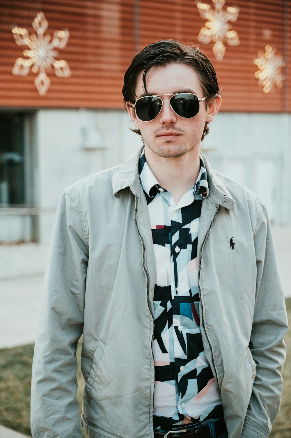 man wearing gray Ralph Lauren zip-up jacket and sunglasses standing