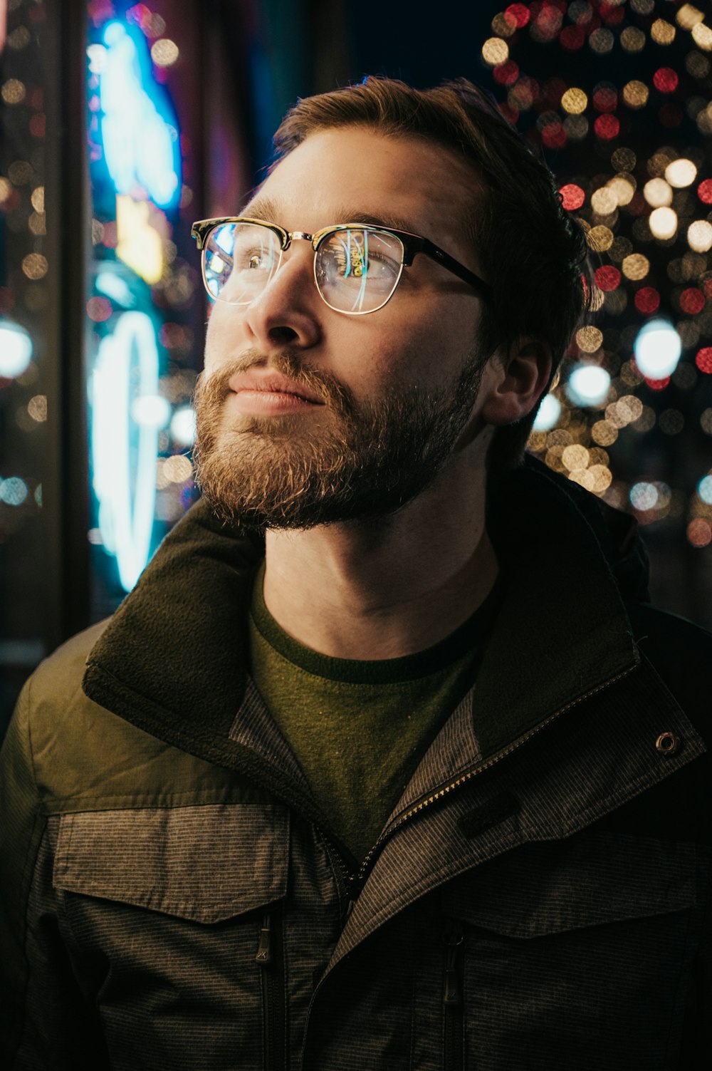 man in gray and green collared jacket wearing eyeglasses with turned-on lights