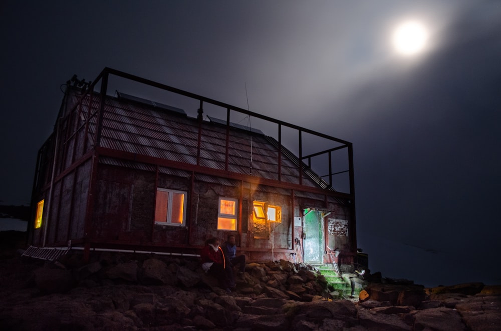 house with turned-on light under a full moon
