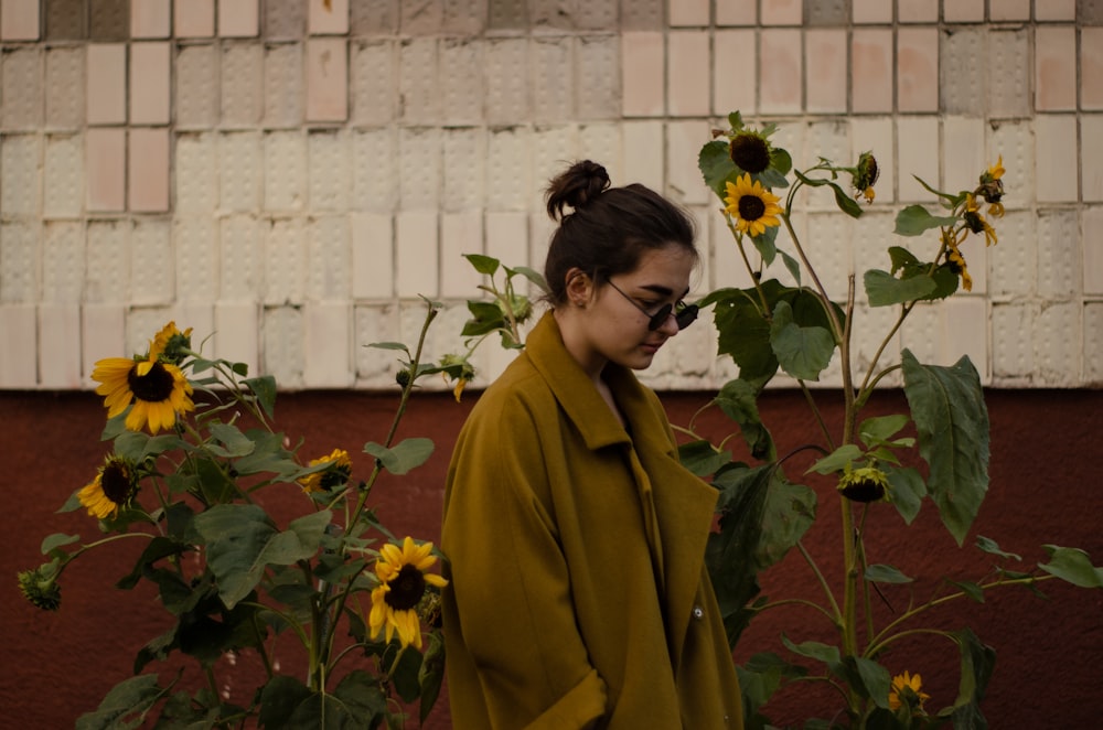 woman wearing brown coat near the sunflower