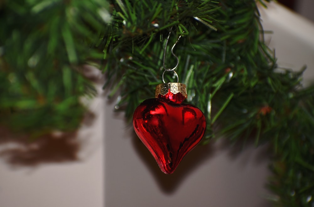 heart-shaped red ornament hanging on a Christmas tree