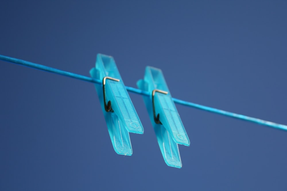 due mollette di plastica blu su uno stendibiancheria blu