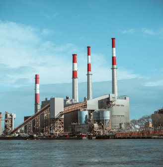 gray and red factory building under a calm blue sky