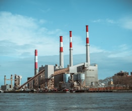 gray and red factory building under a calm blue sky