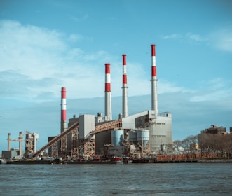 gray and red factory building under a calm blue sky