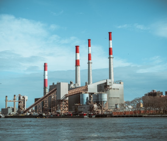 gray and red factory building under a calm blue sky