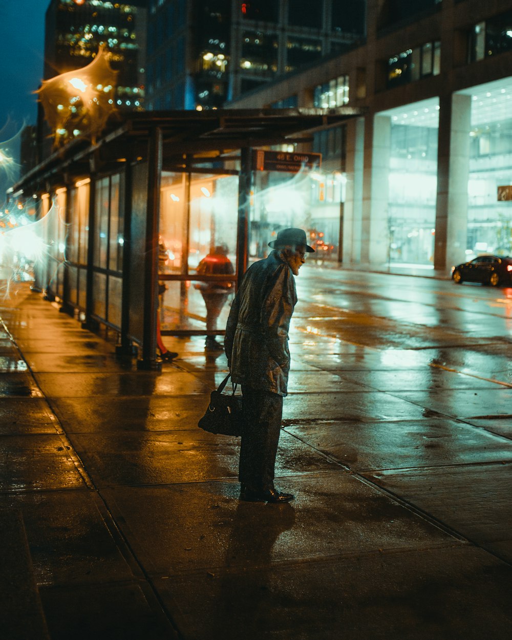 man carrying bag standing beaisde shed