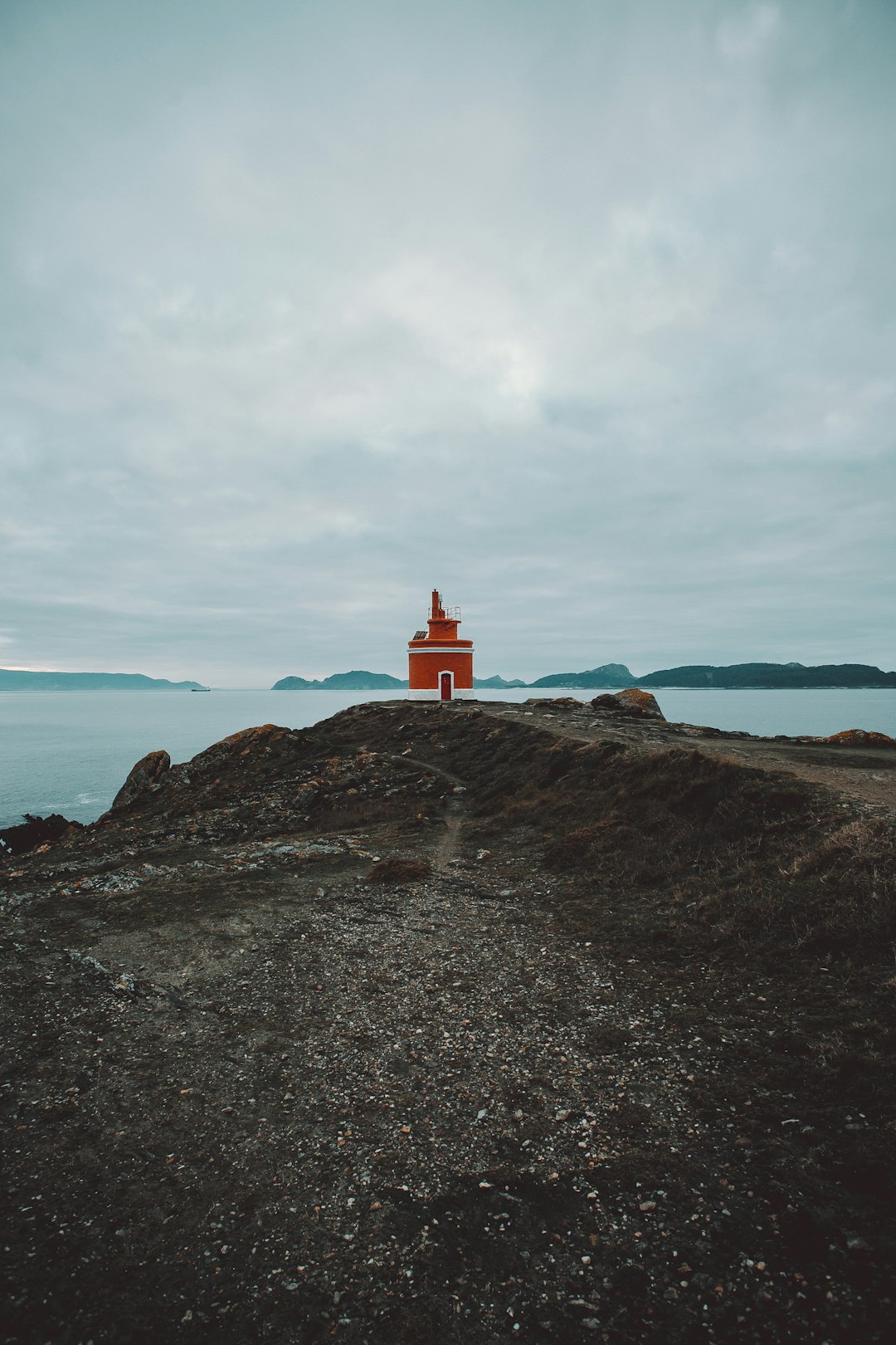red lighthouse on island during day