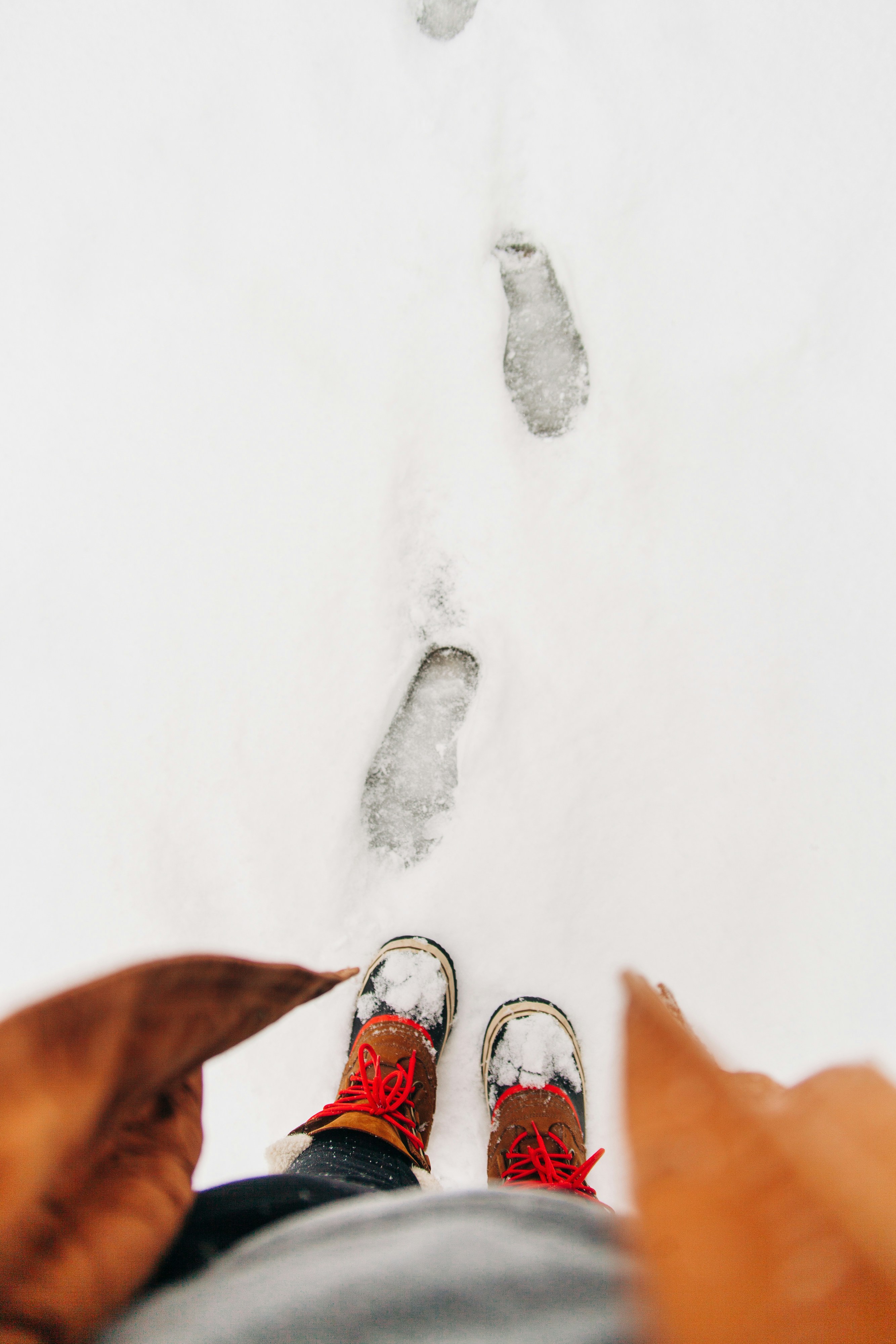 person standing on snowfield with footprints