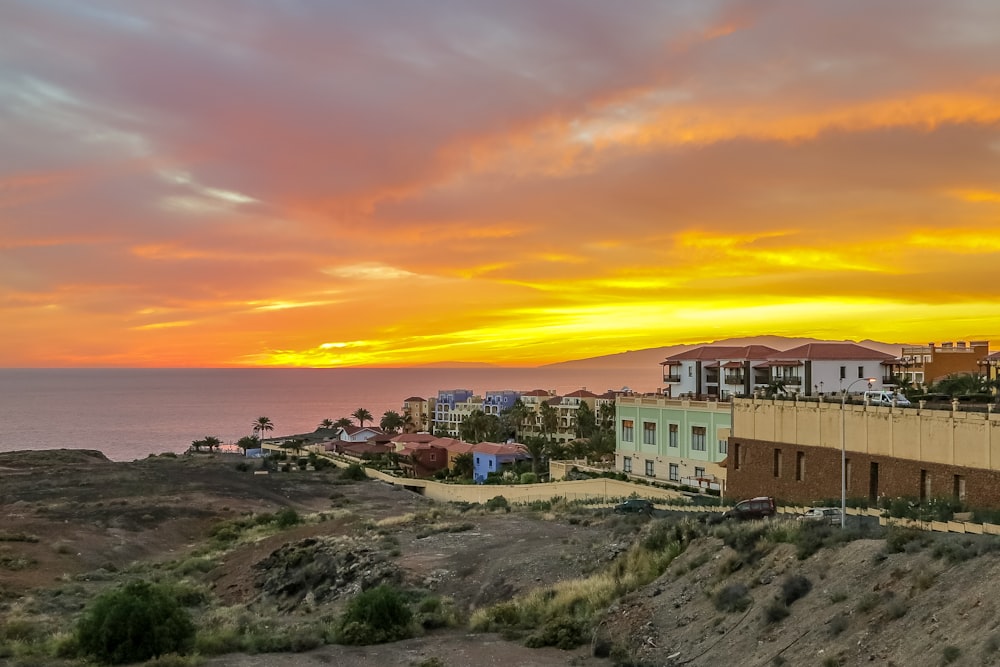 concrete buildings on rocky terrain during golden hour