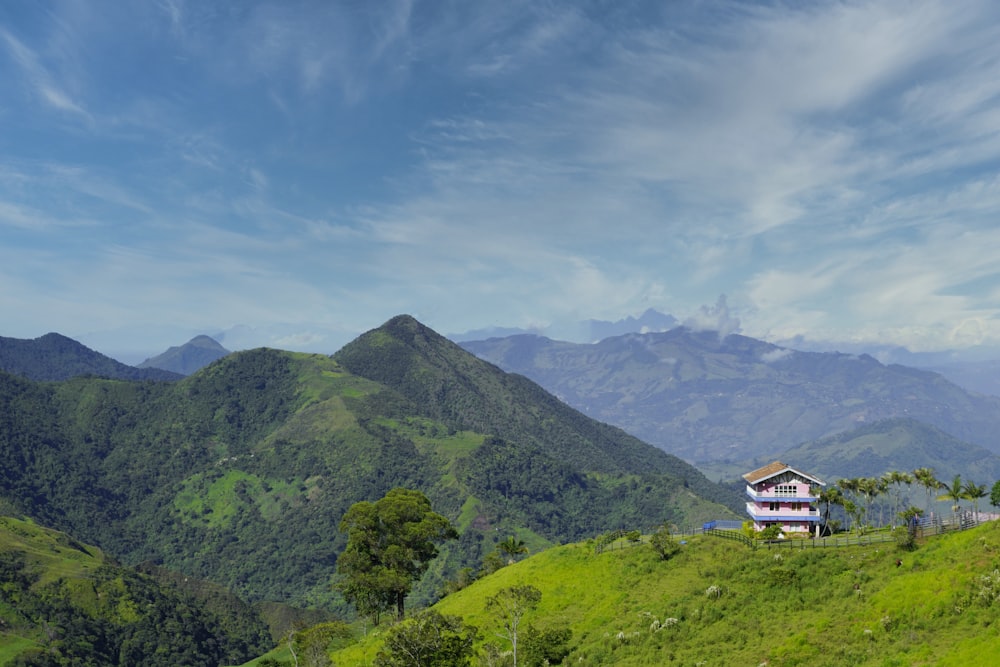 3-story house on top of hill near mountains at daytime