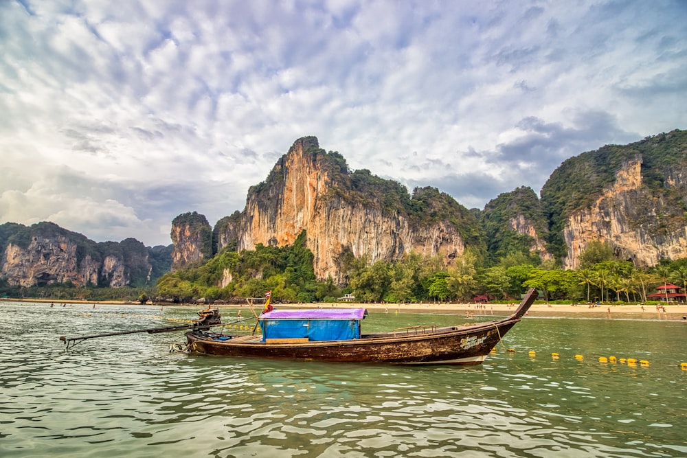 boat on water near mountains at daytime