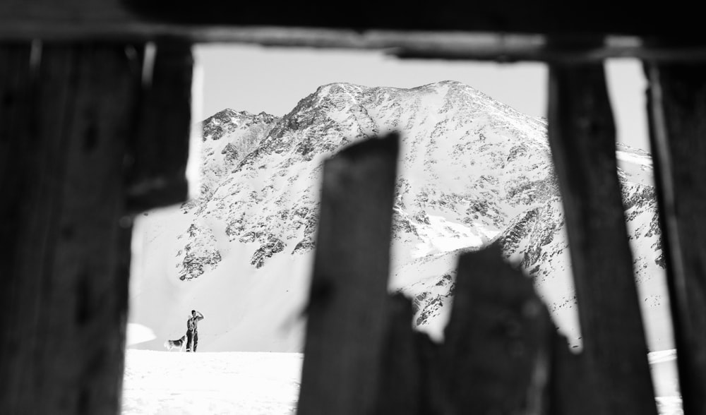 hombre de pie cerca de la fotografía de la montaña nevada