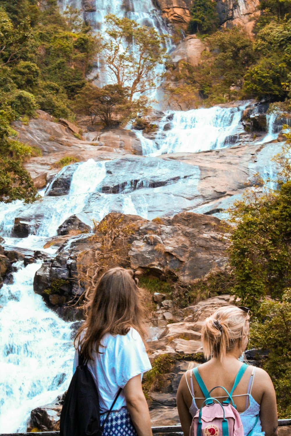 two women looking at a flowing multi-tier waterfall