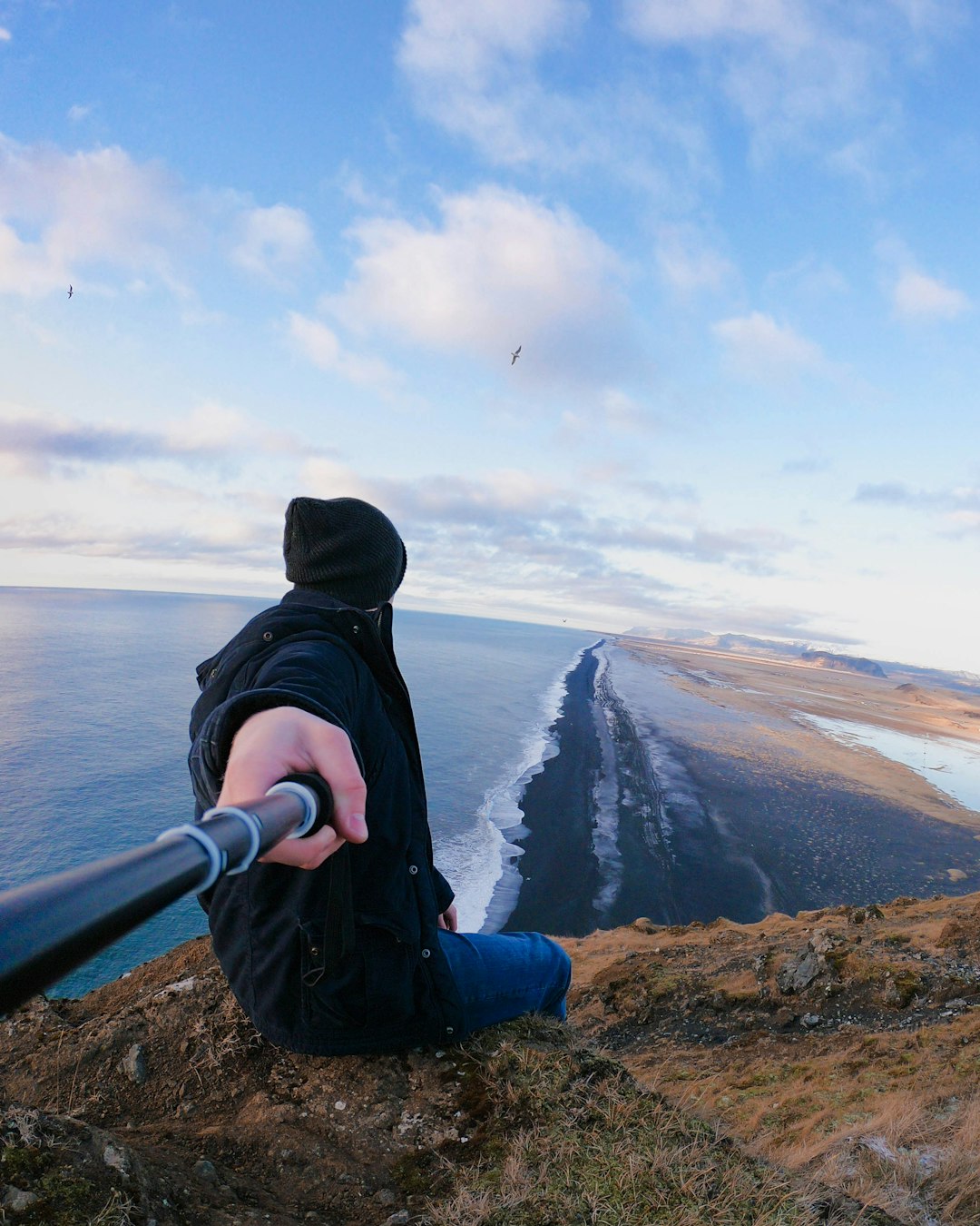 person sitting on the mountain cliff