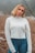portrait photography of woman wearing white sweater and blue denim jeans