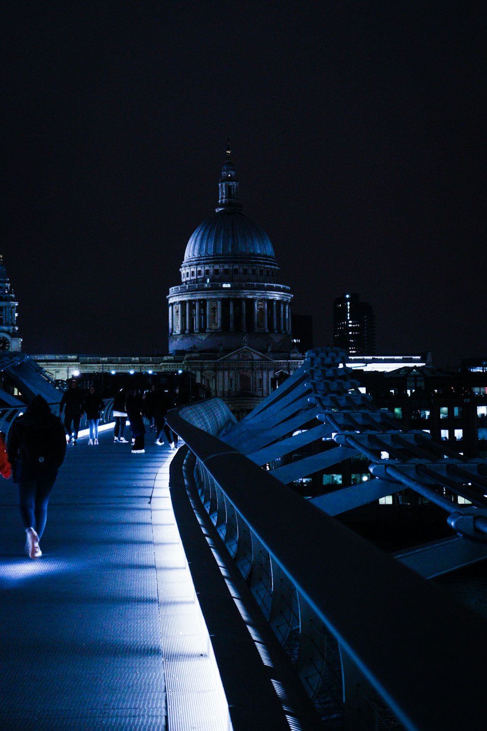 a person walking down a bridge at night