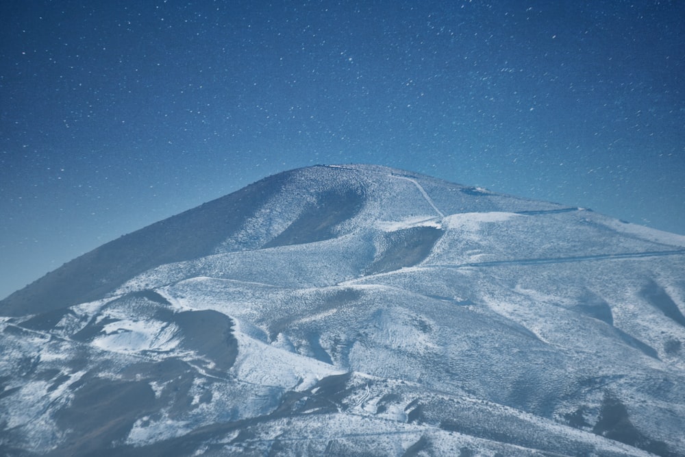 a mountain covered in snow under a blue sky