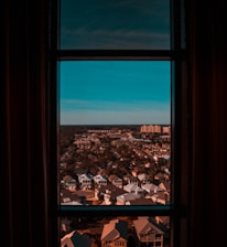 Wide shot of a clean Adelaide neighborhood with gleaming windows reflecting the blue sky.