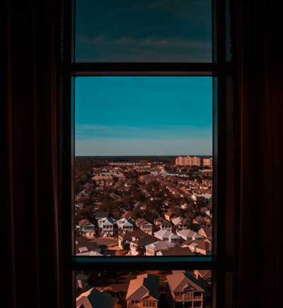 Wide shot of a clean Adelaide neighborhood with gleaming windows reflecting the blue sky.