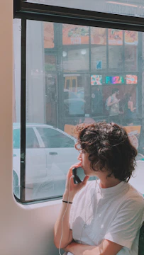 A friendly concierge speaking on the phone while looking at pizza menus on a laptop.