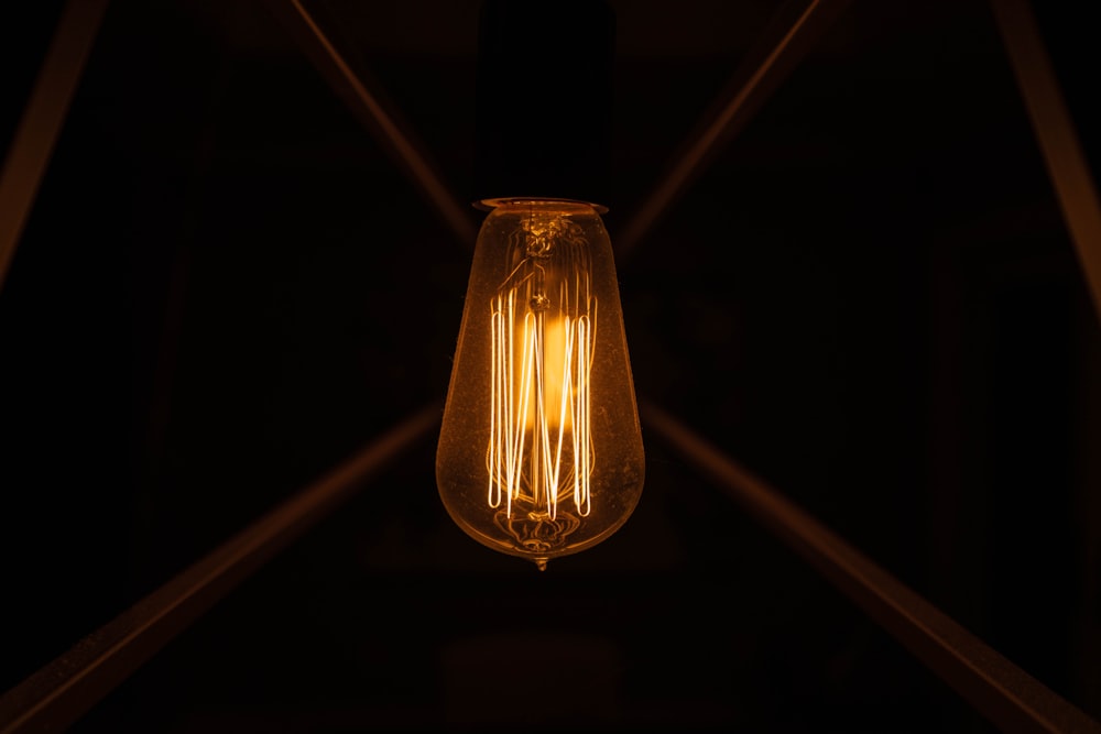 uma lâmpada pendurada no teto em um quarto escuro