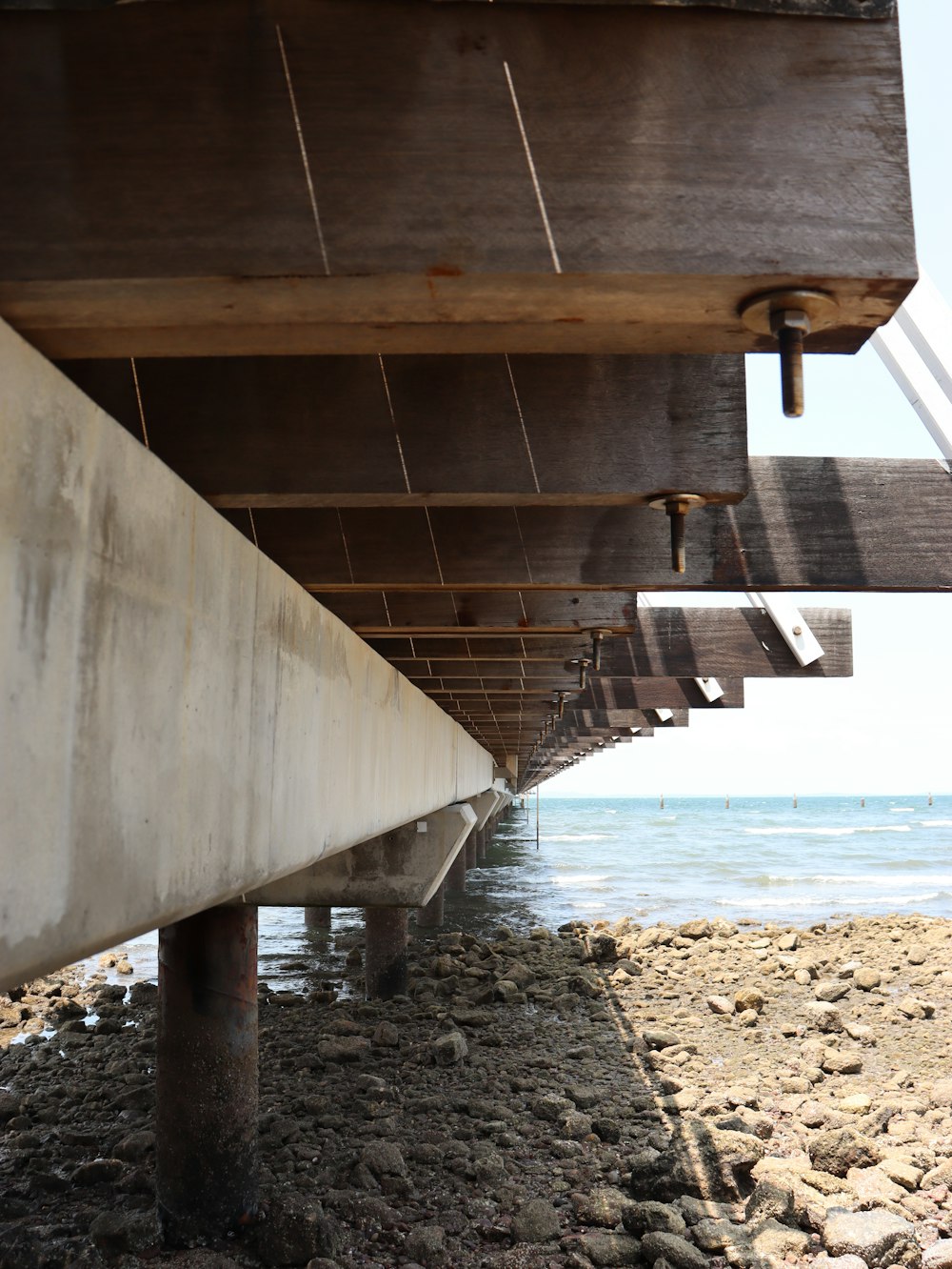 the underside of a bridge over a body of water