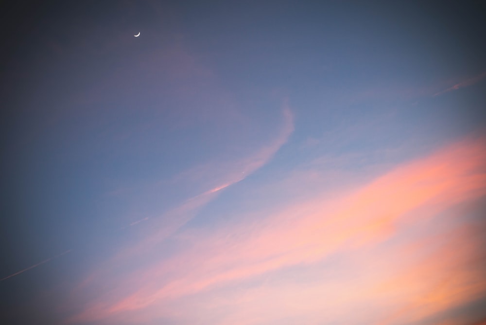 a plane flying in the sky at sunset